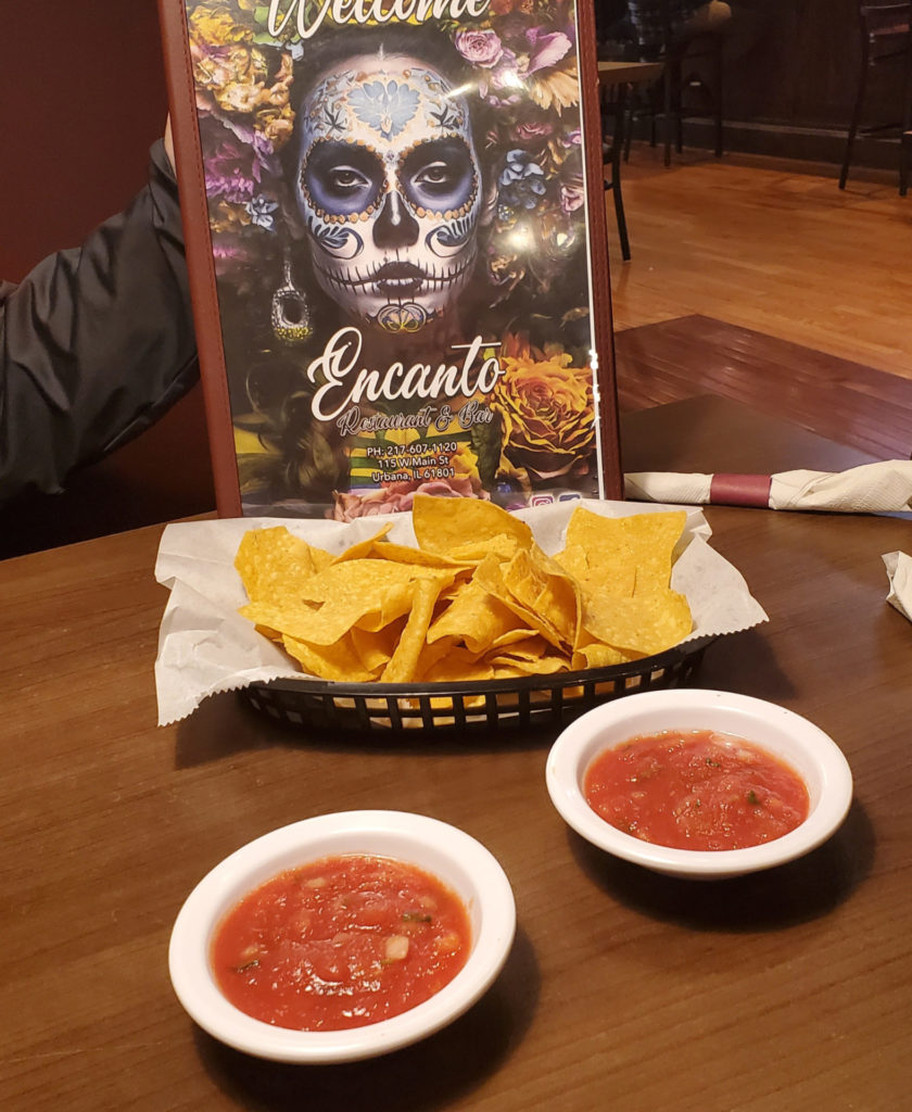 The menu with chips and salsa on a table inside Encanto Restaurant and Bar.