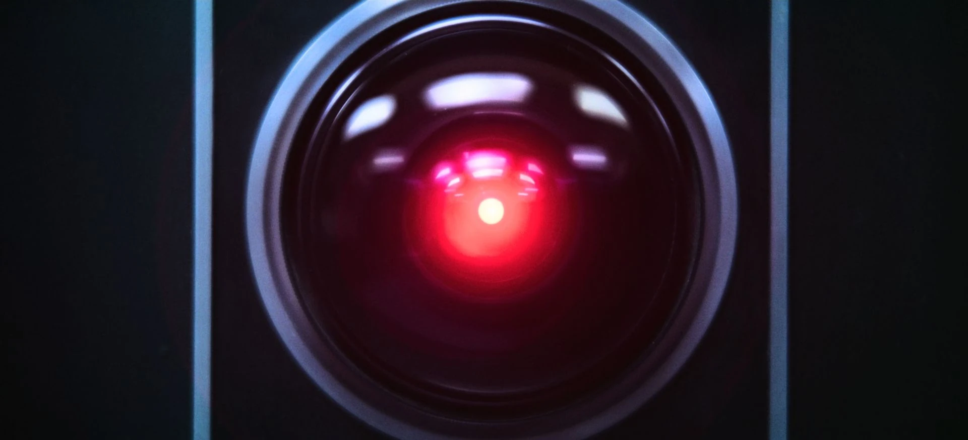 Close up of HAL 9000 from a 2001: A Space Odyssey. A red pinpoint of light surrounding by a circle of glass.