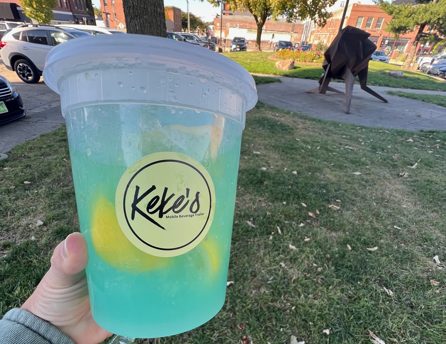 A large plastic container with a light blue liquid and lemon wedges.