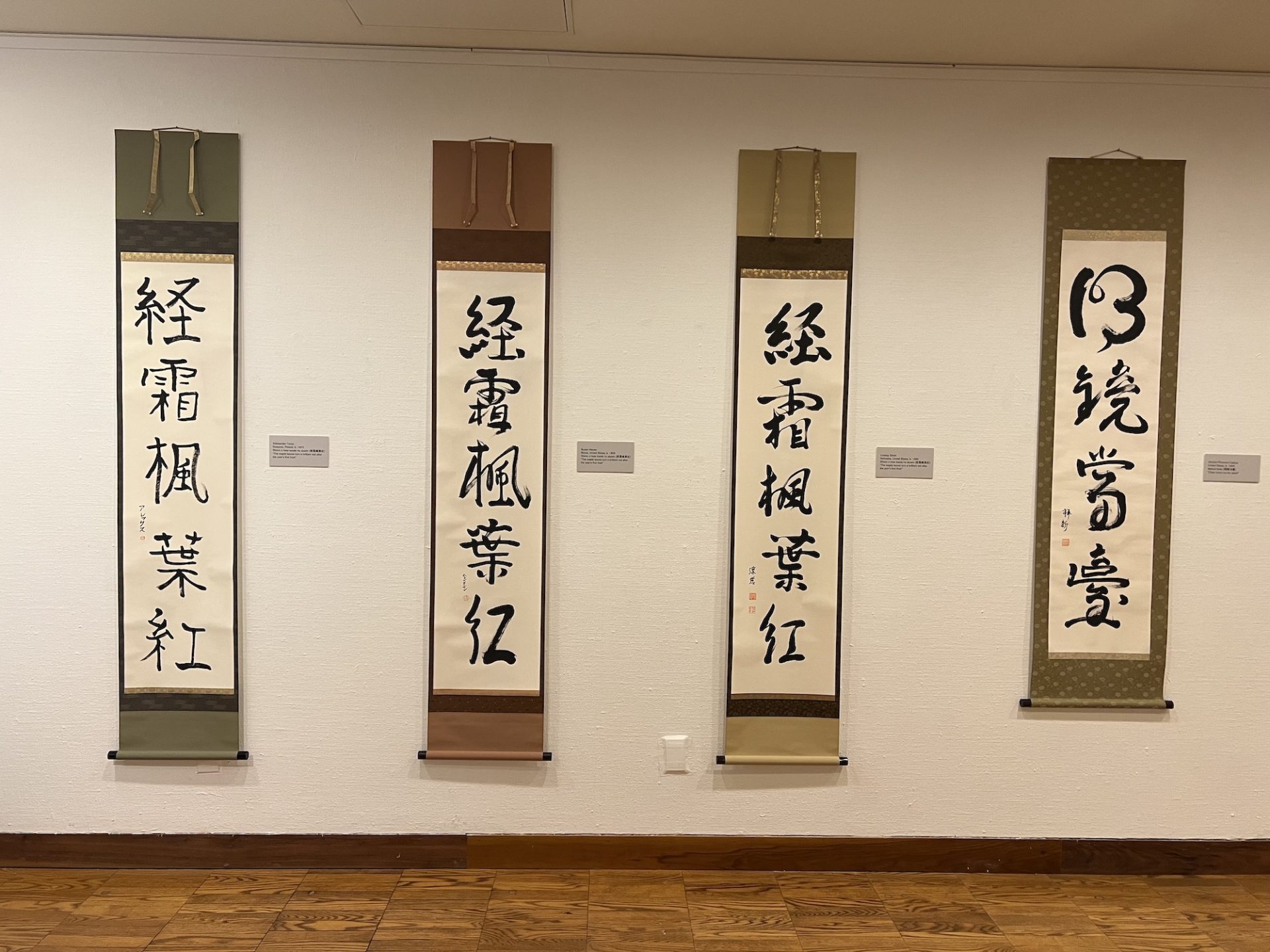 Four scrolls of Kanji calligraphy hang vertically, reaching almost floor to ceiling