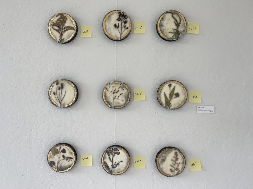 Three rows of three round pieces, all beige and gold, each featuring a flower. Each has a "sold" post-it next to it