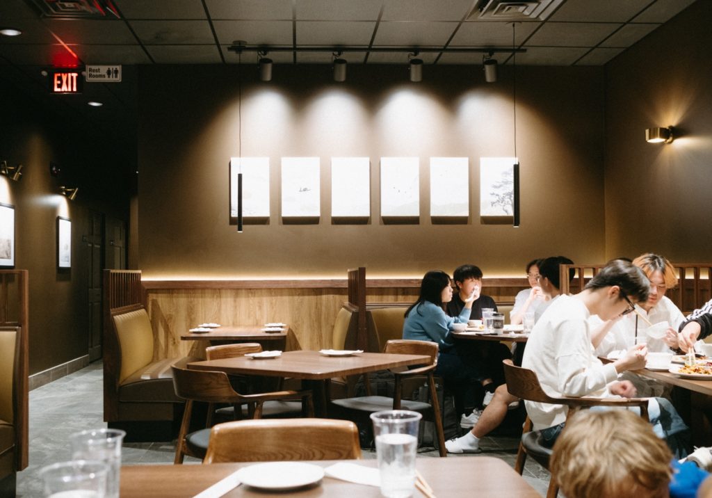 A restaurant with a brown wall and lights along the back wall