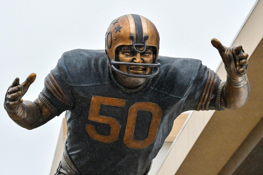 A statue of Dick Butkus, wearing a blue and orange Illini football uniform.