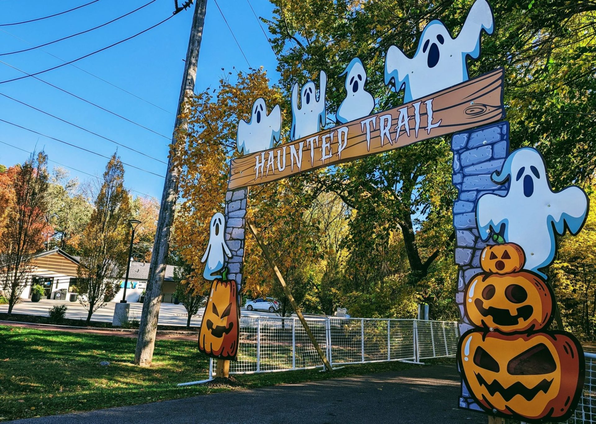Entrance to a trail, decorated with painted ghosts and jack-o-lanterns.