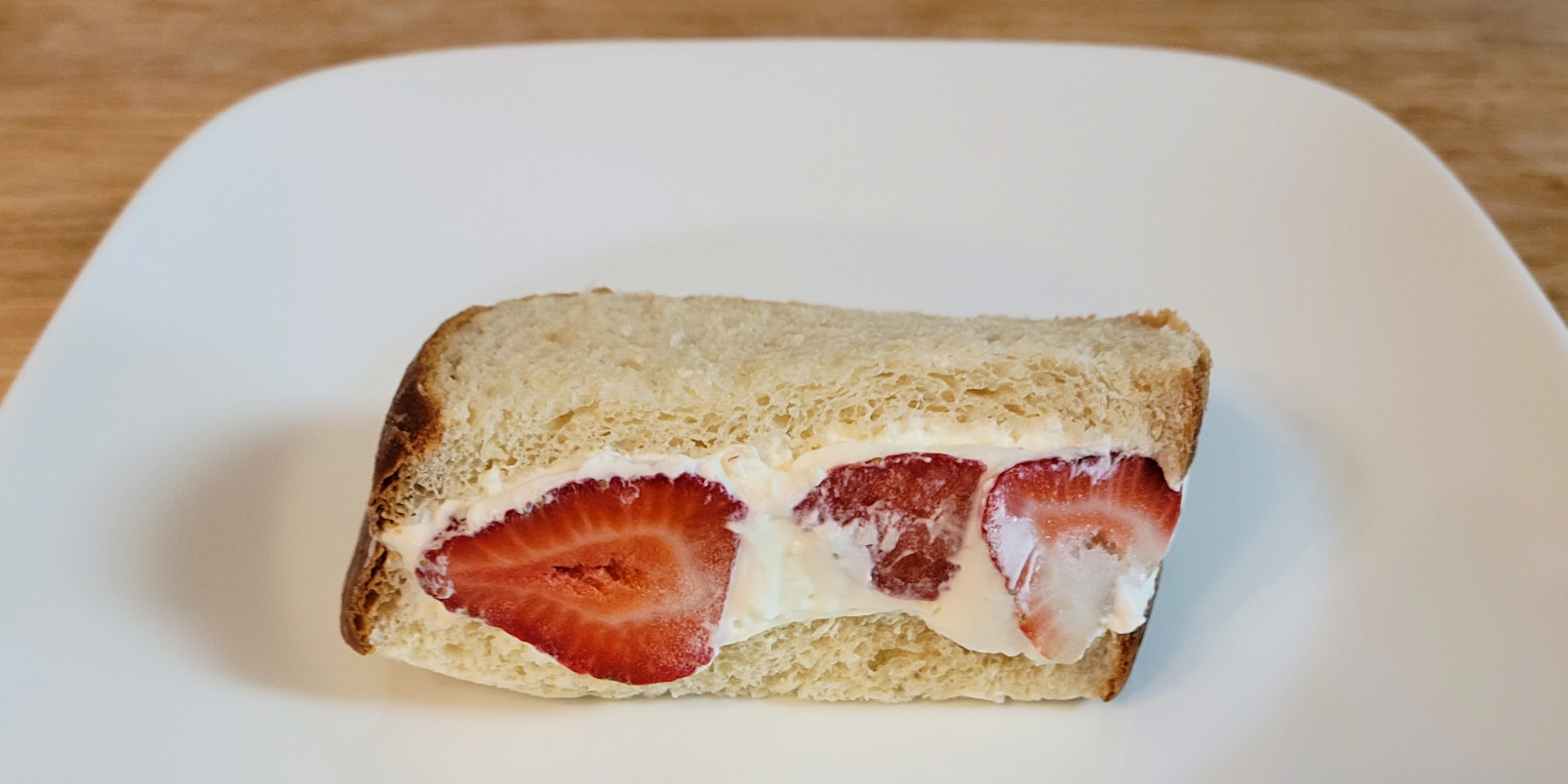 A fruit sandwich with whipped cream and strawberries between homemade bread by Kaori's Oven