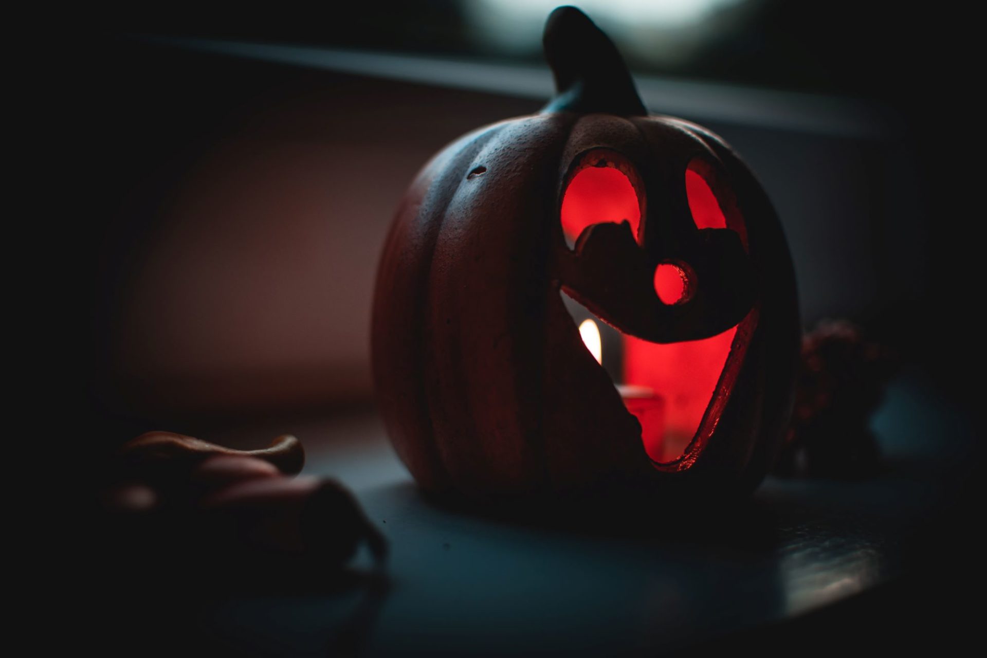 A lighted jack-o-lantern with two large eyes, a small nose, and a large smiling mouth.