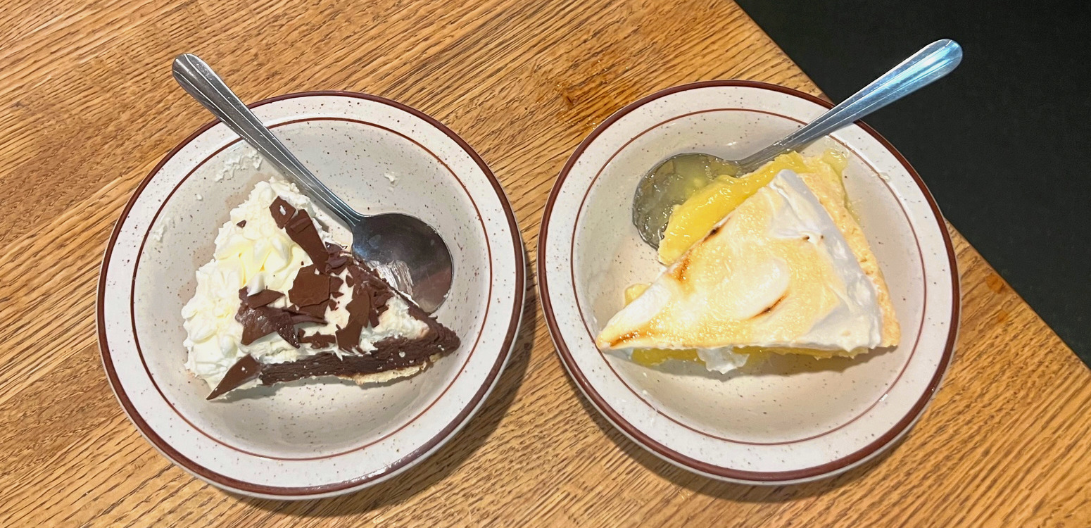 Two slices of pie in a bowl, served with a spoon spoong