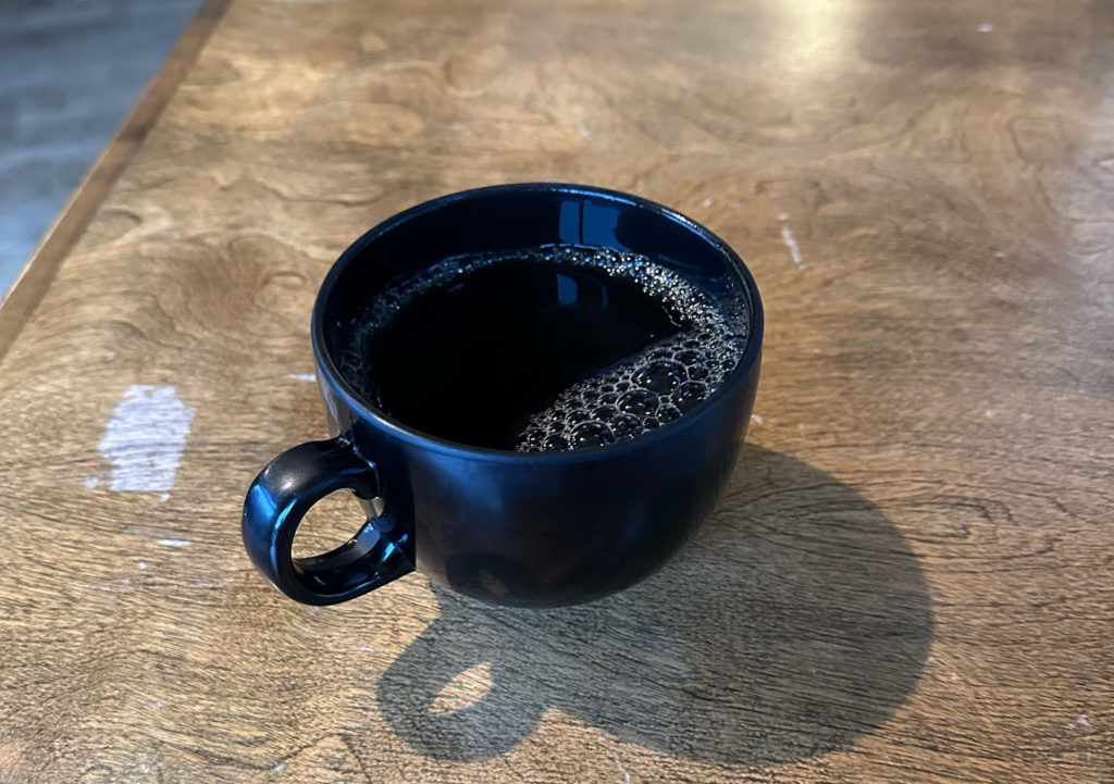 A pour over coffee in a black mug at Flying Machine Avionics.