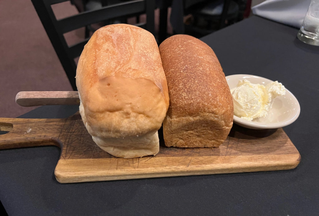 Two loaves of bread speared with a knife.