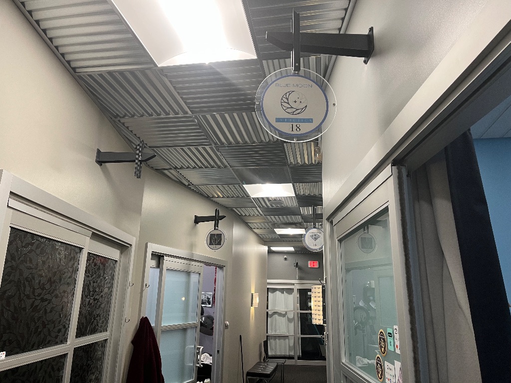 The hallway outside Blue Moon Esthetics. The sign above her door has the logo of a moon and three stars. 
