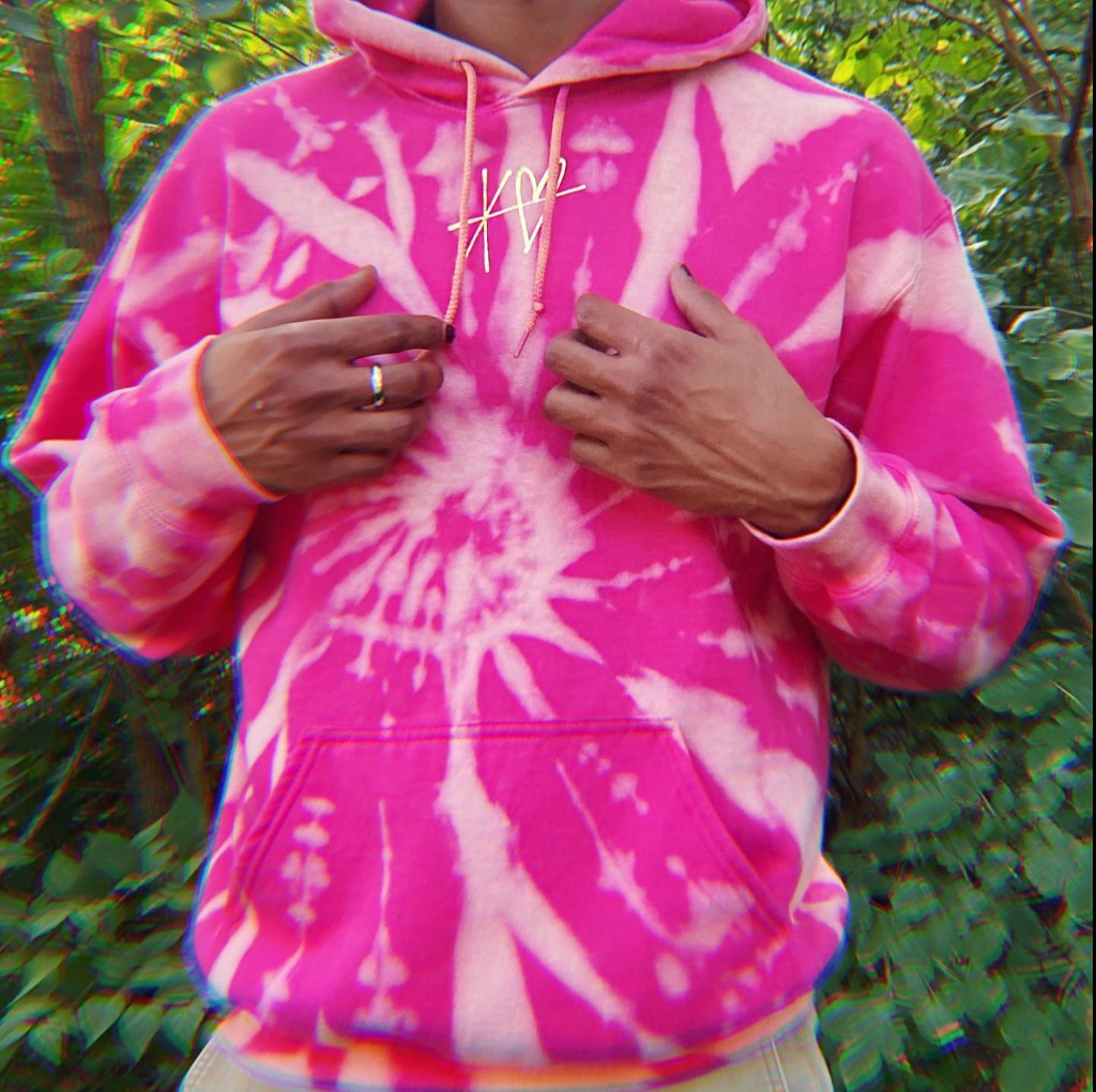 a person wears a pink and white tie dye sweatshirt you can only see their hands and chest. 