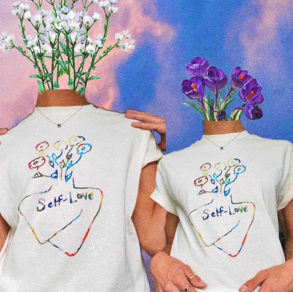 Two models in white t-shirts with rainbow screen printing stand in front of a blue and pink cloudy sky. The models don't have heads and instead purple and white flowers are growing out of their necks.