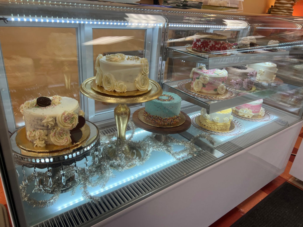 Inside a glass case, there are decorated cakes.
