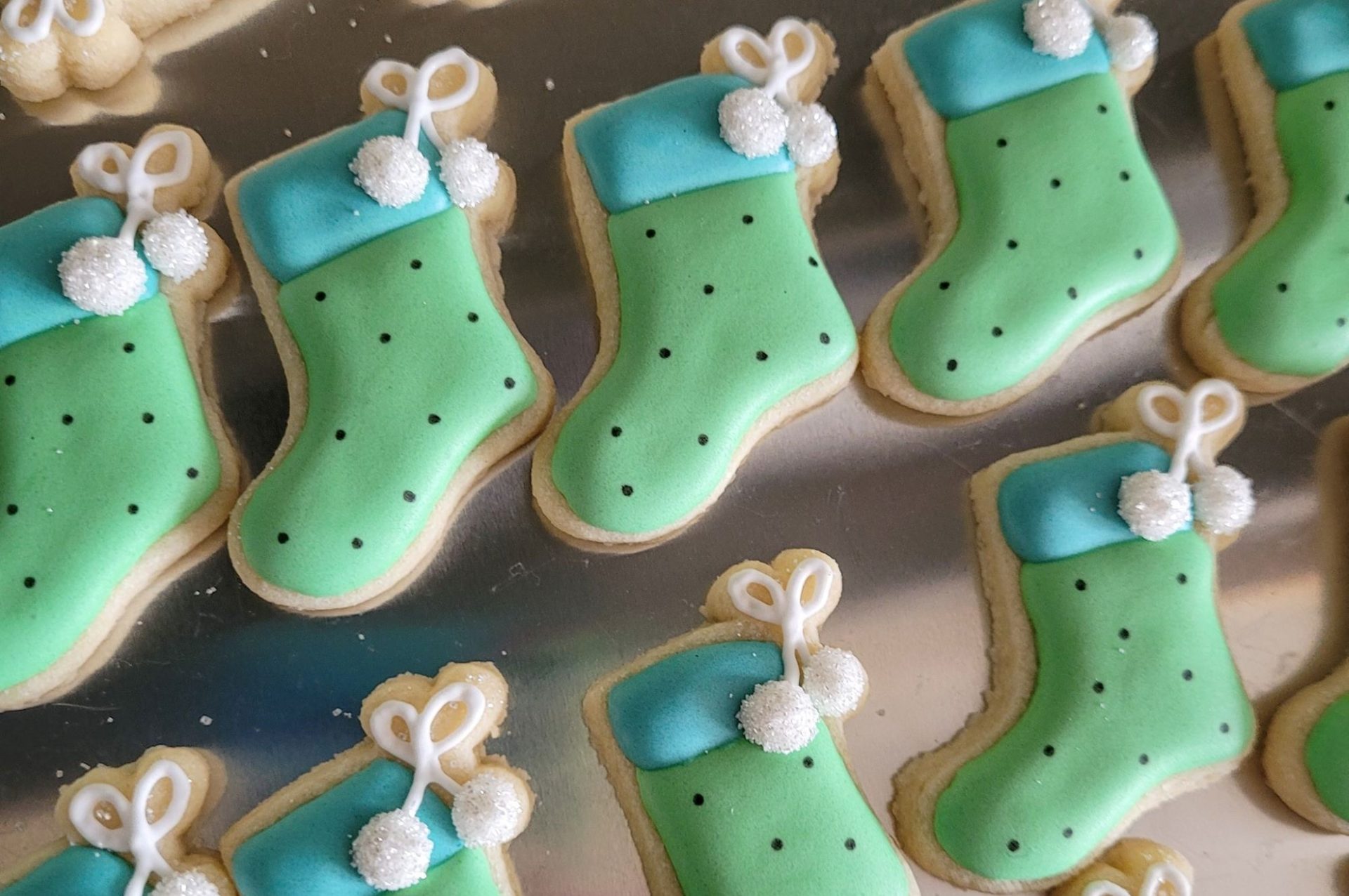 Rows of stocking shaped sugar cookies withh green and blue frosting.
