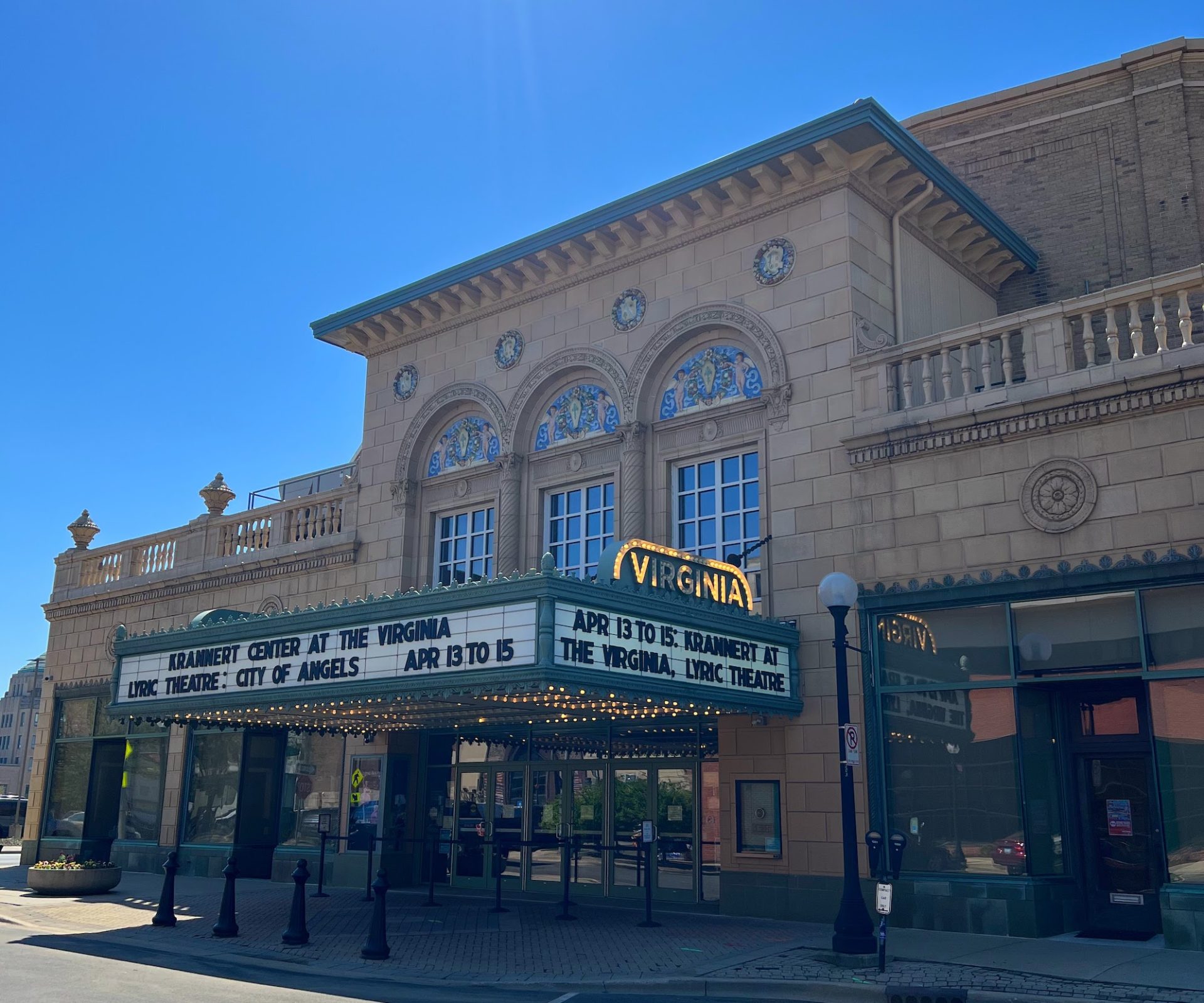 Exterior of the Virginia Theatre against a bright blue sky. The marquee reads "Krannert Center at the Virginia"