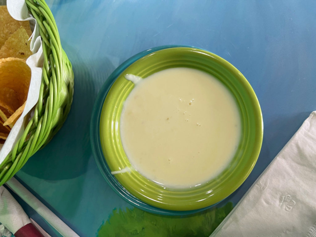 A small green bowl of white queso.