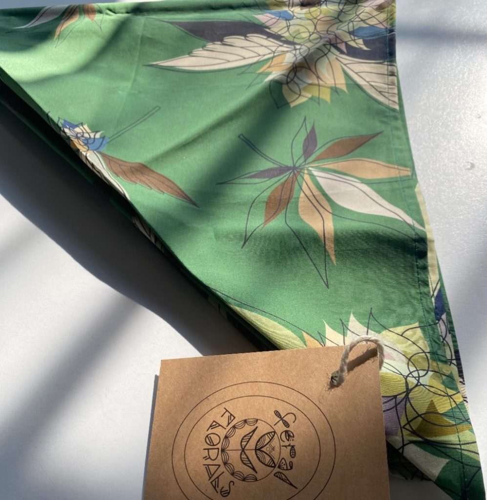 A green bandana with a cannibis print in the sunlight.
