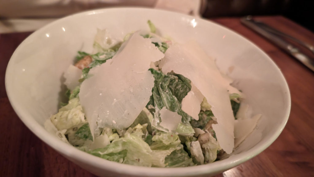 Caesar salad in a white bowl.