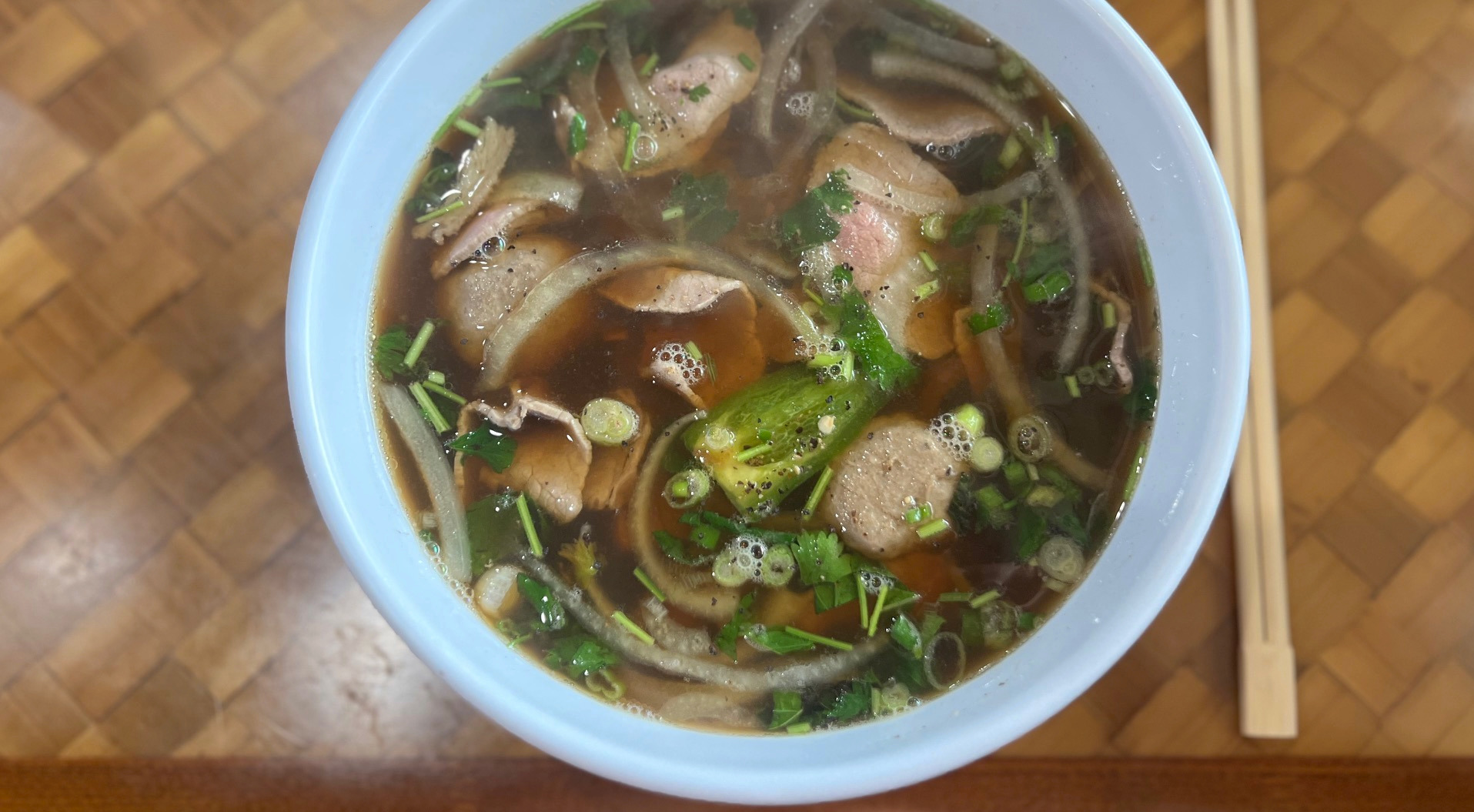 A white bowl holds pho from 83 Vietnamese restaurant in Champaign, Illinois.