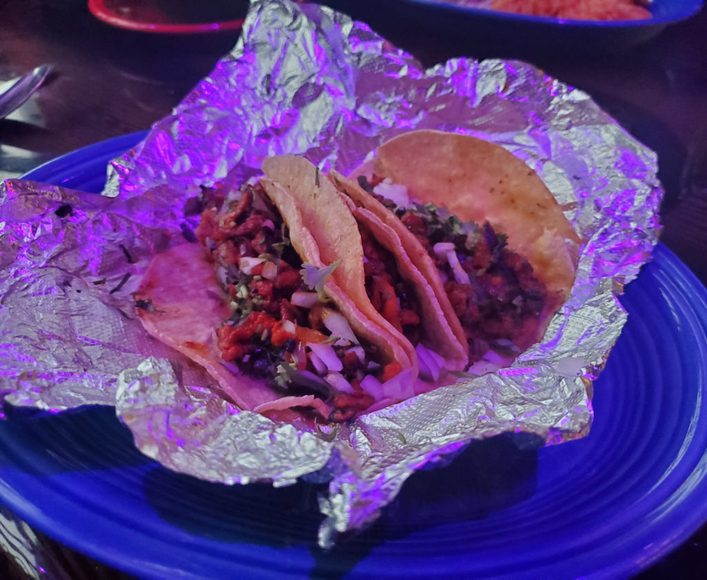 Tacos in tin foil on a blue ceramic plate at Hacienda Agave in Champaign, Illinois.