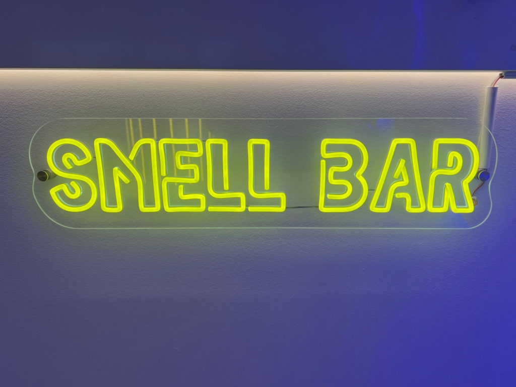 A yellow neon light that reads: Smell Bar inside a cannabis dispensary in Champaign, Illinois.