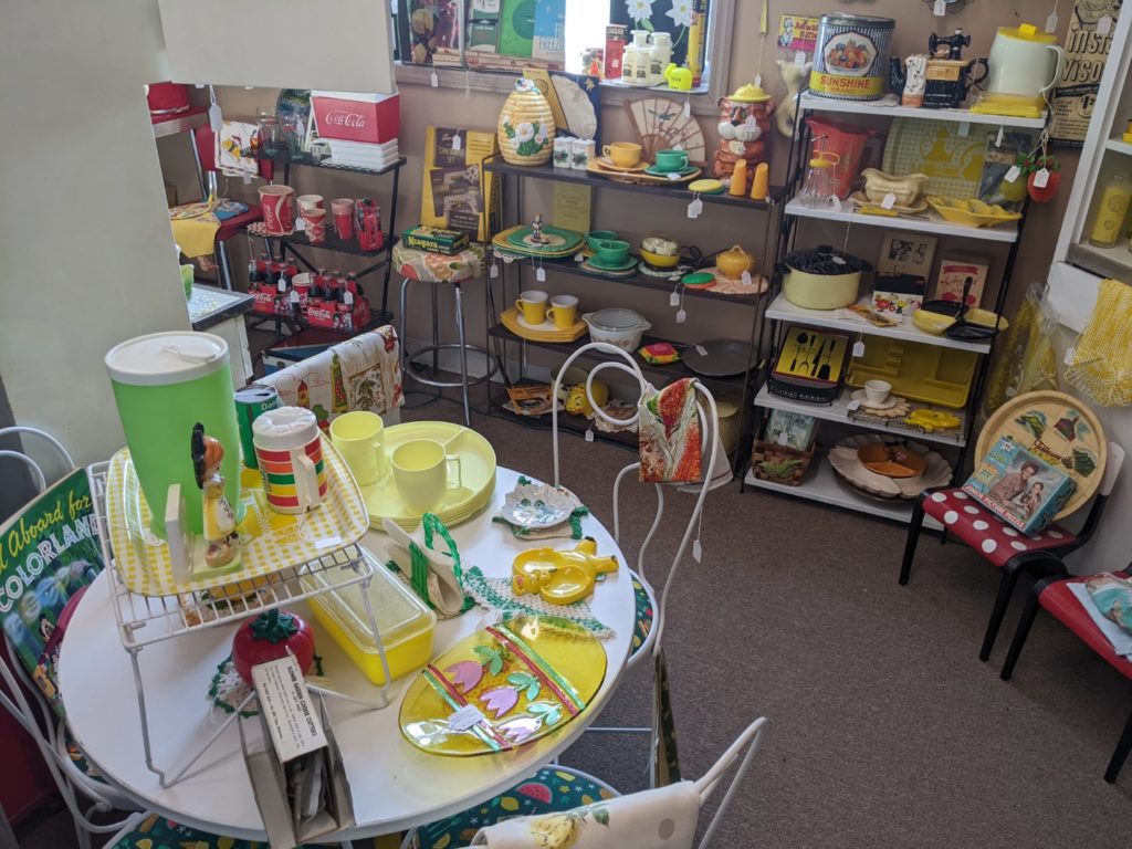 A room of Antique kitchen ware. Most of the colors in this picture are yellow and green on the very left edge you can see the beginning of the red section. 