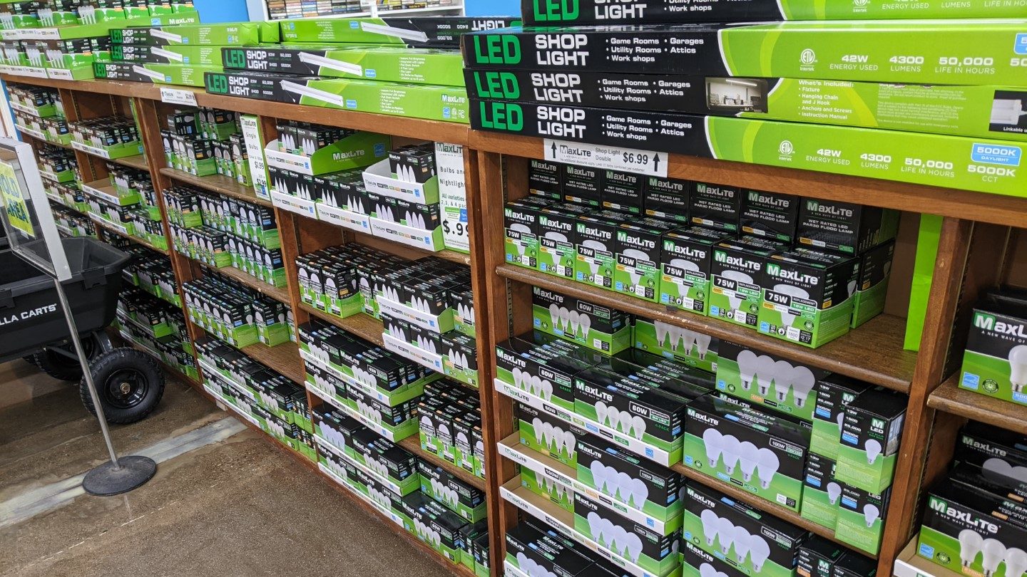 A shelf of lightbulbs in green and black boxes. 