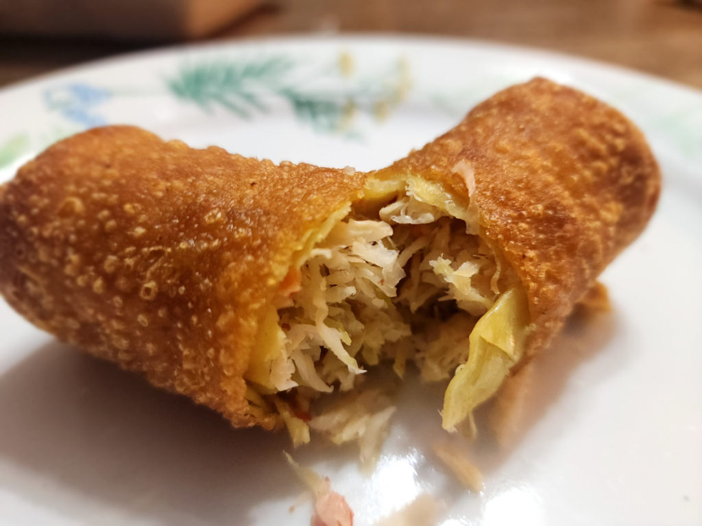 A sliced open egg roll on a white plate.