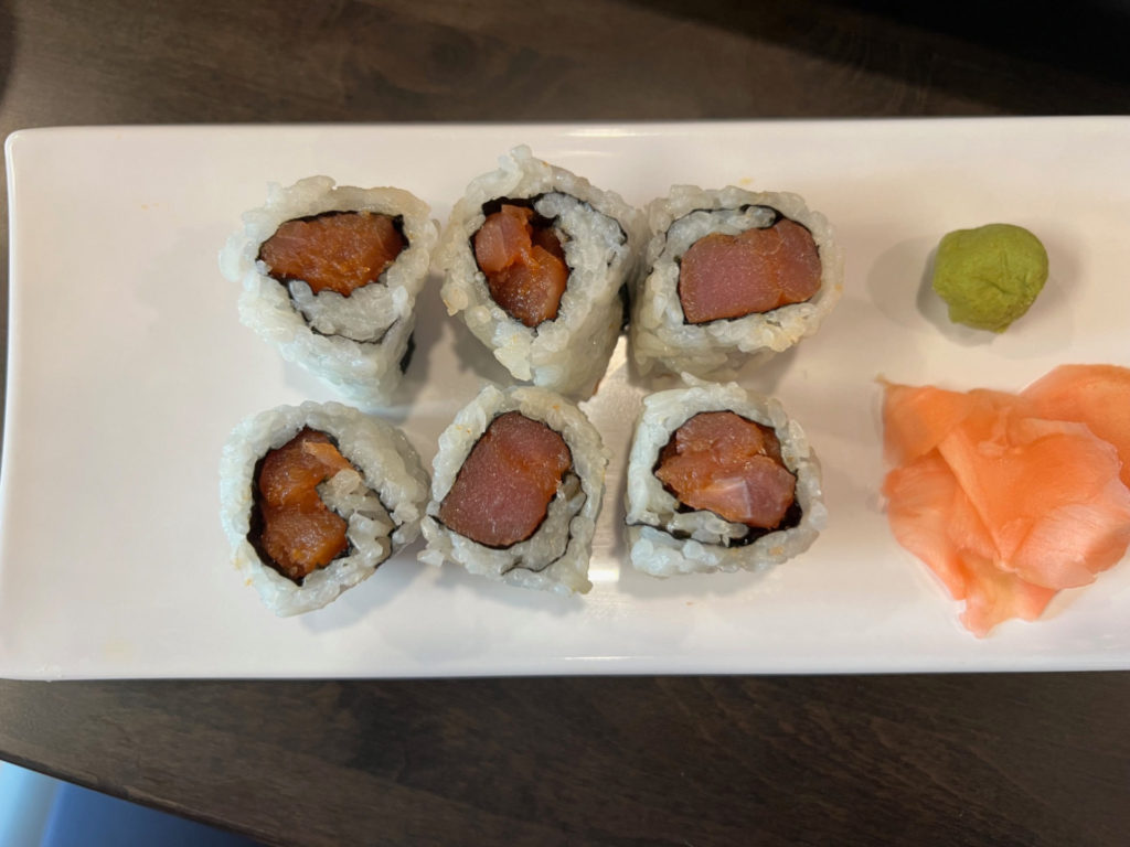 Six pieces of a spicy tuna roll.
