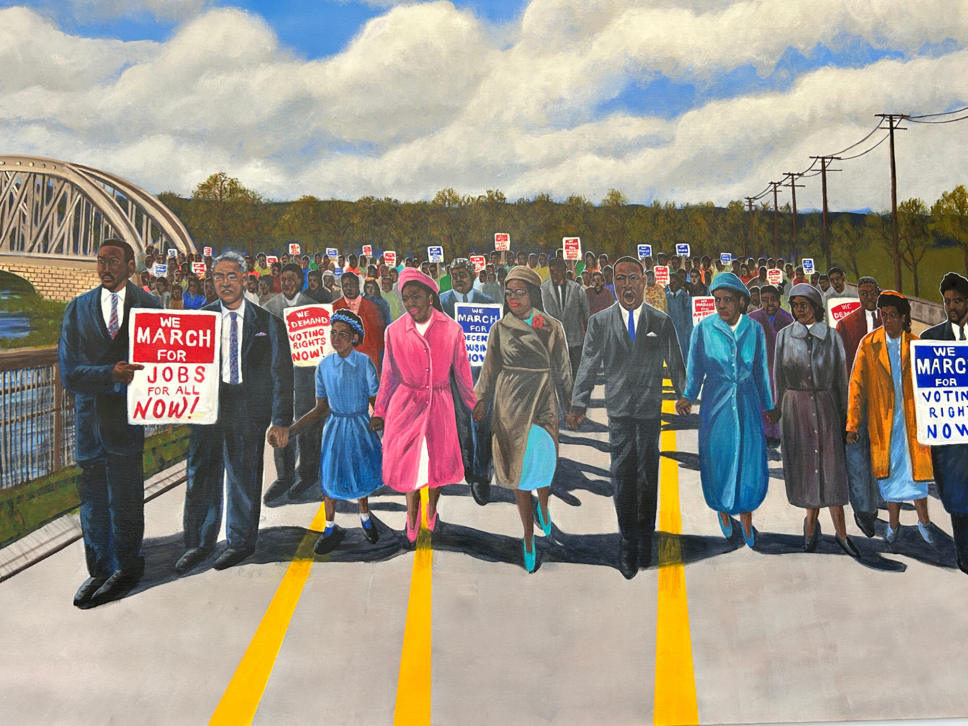 Colorful painting of the famous Selma march with drawings of the Black marchers wearing pink and blue coats, carrying signs that read "We march for jobs for all now," and "We march for voting rights now." The figures are holding hands leading the march.