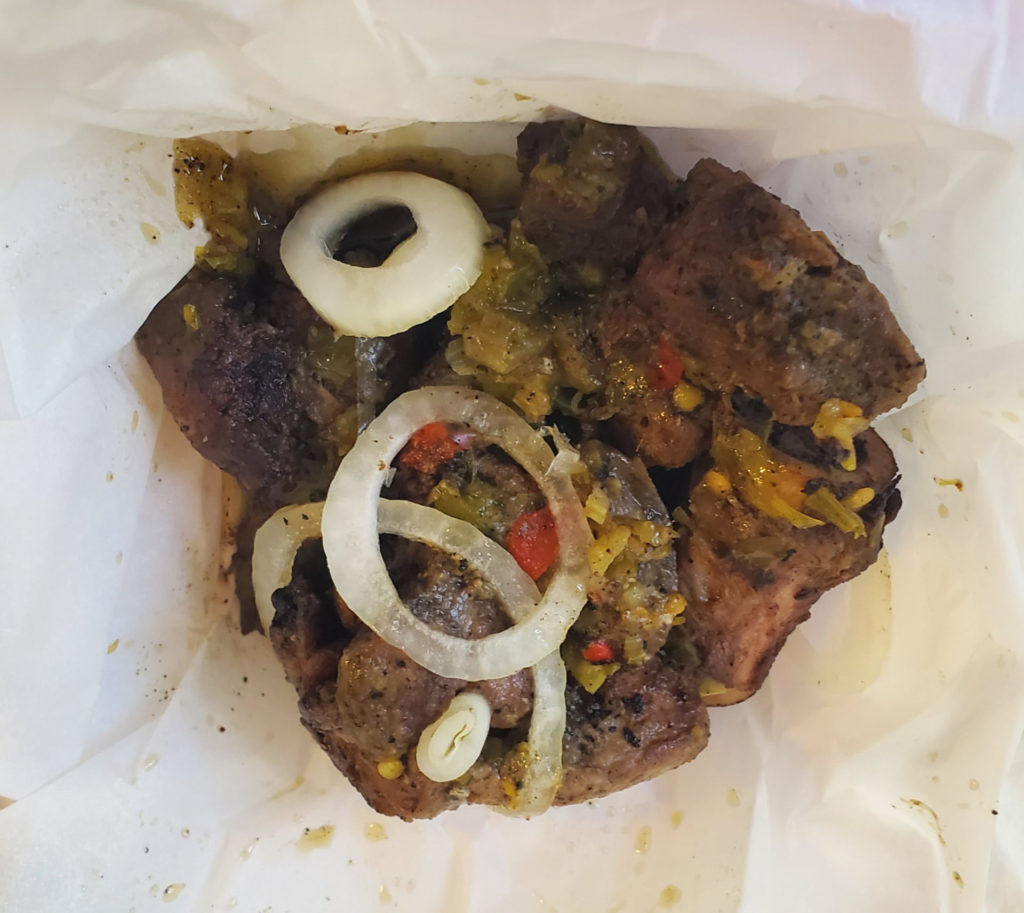 A bag of pork with white onions on top.