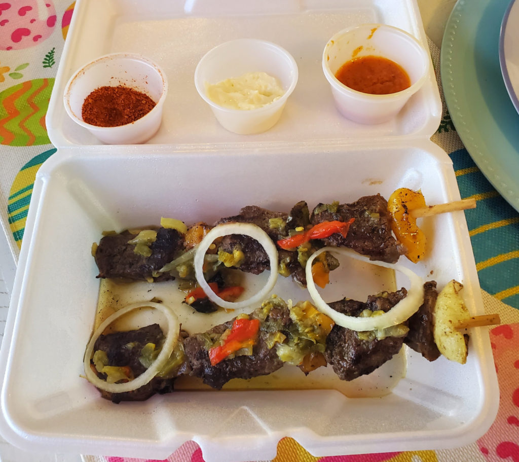 Two skewers of steak with veggies in a styrofoam container.