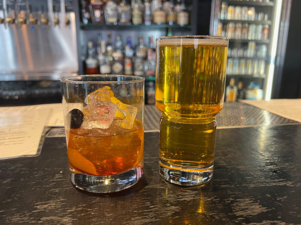 An old-fashioned cocktail and a beer on the bar at Collective Pour in Downtown Champaign.