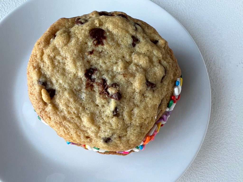 A chocolate chip cookie sandwich with rainbow sprinkles.