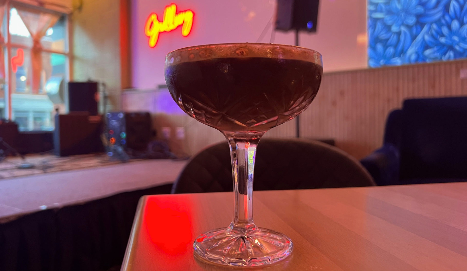 A brown cocktail in a glass goblet inside Gallery Art Bar in Urbana.