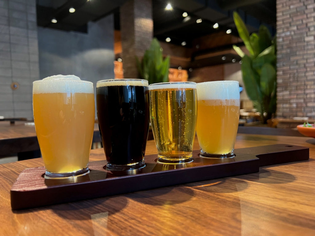 Four beers on a beer paddle as a beer flight for Tenkyu.