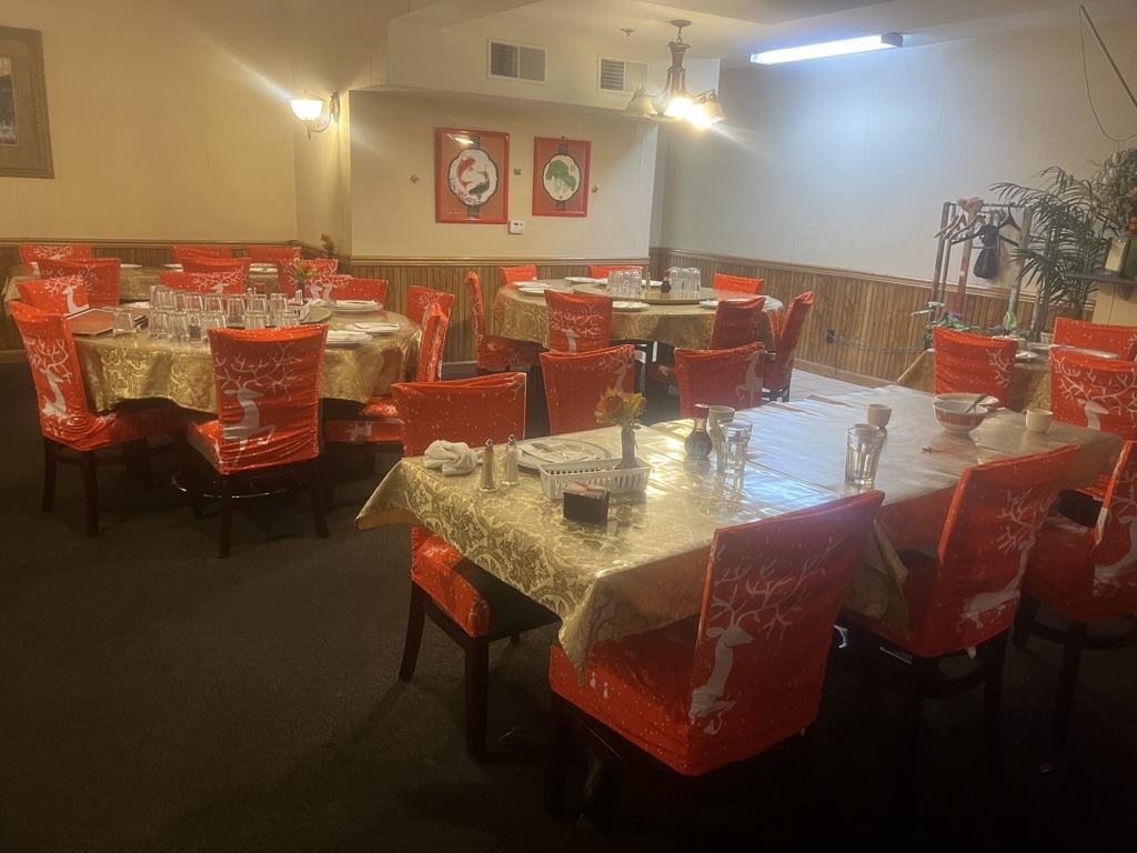 The dining room of Peking Garden has red chairs with white-tableclothed tables.