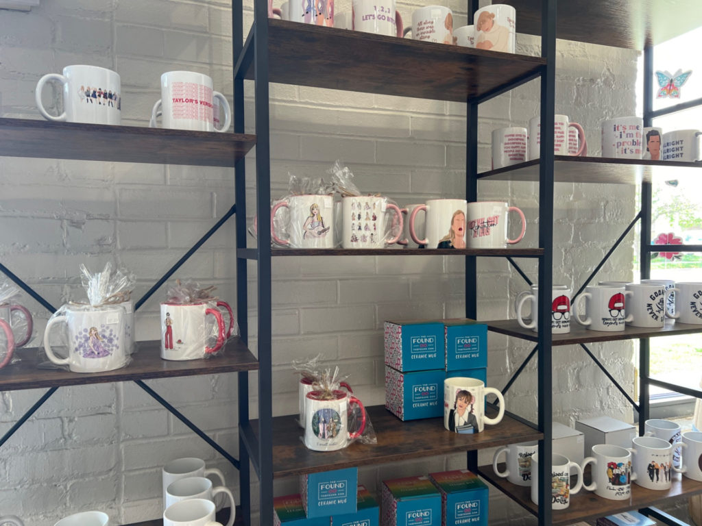Shelves of coffee mugs with popculture references for sale at Columbia Street Roastery.