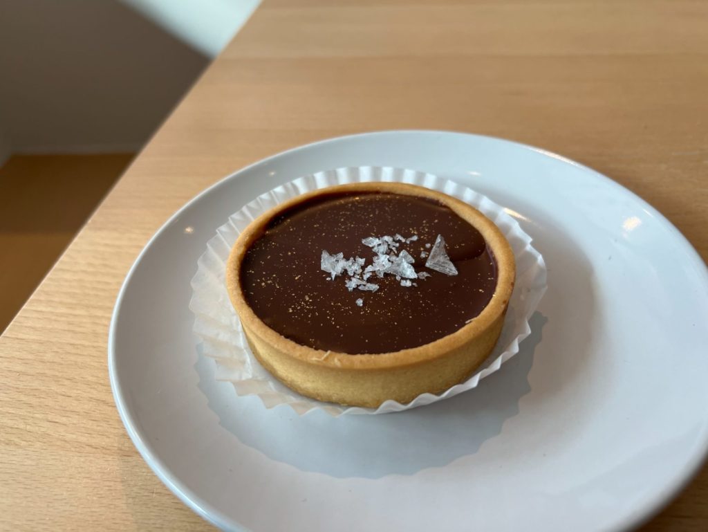 The caramel tart from Suzu's on a white plate.