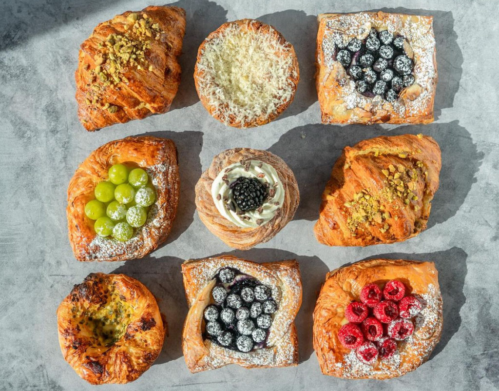 Nine pastries in a grid on a gray concrete table.
