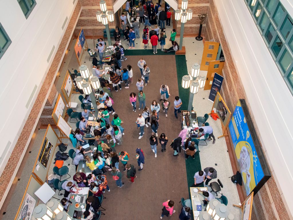 A birdseye view of a large hallway full of people and tables.