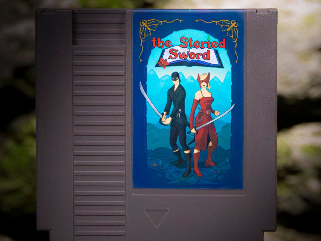 A gray Nintendo game cartridge with the storied stone over two characters standing with their swords drawn. The man is wearing all black and has a black mask covering half of his face and the woman is wearing a long red dress and a red mask covering her eyes. 