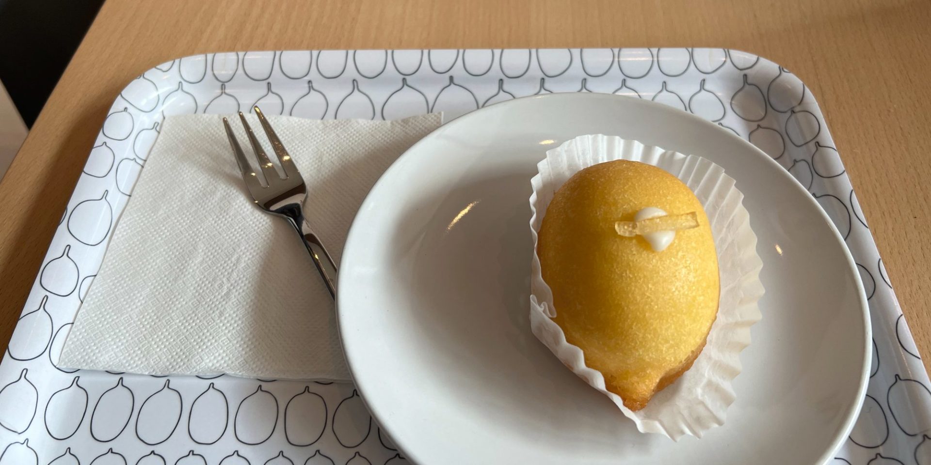 A yellow lemon-shaped treat on a white plate.
