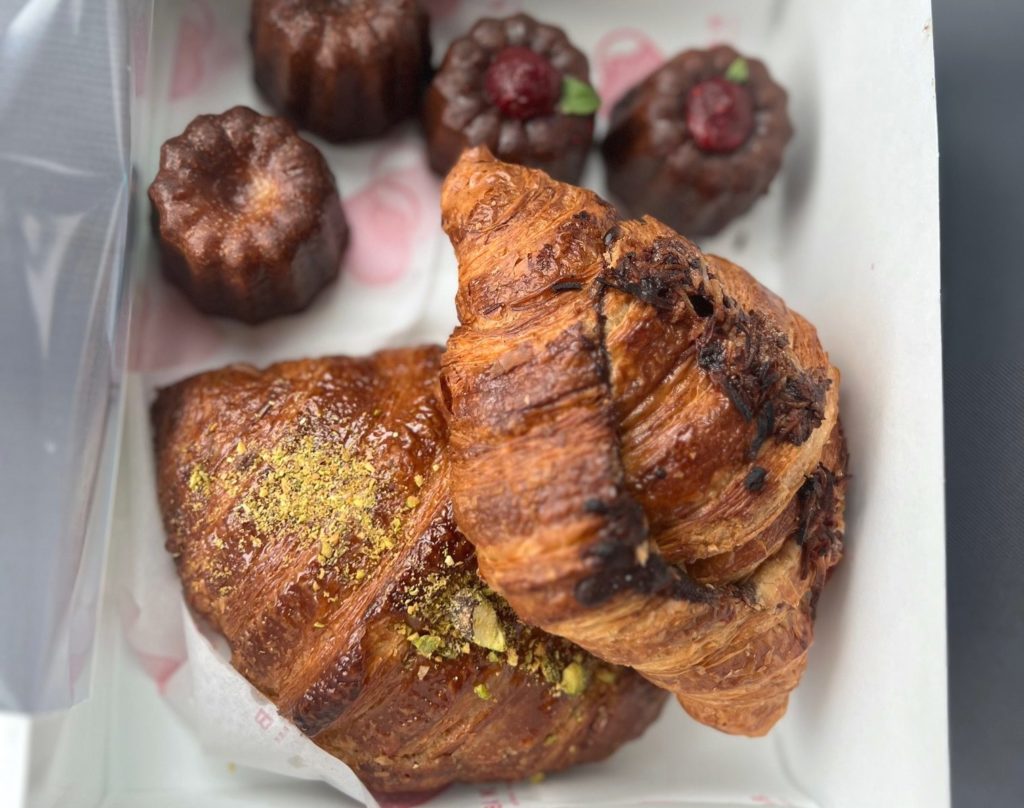 Croissants and cannelés from BakeLab in Urbana in a white box.