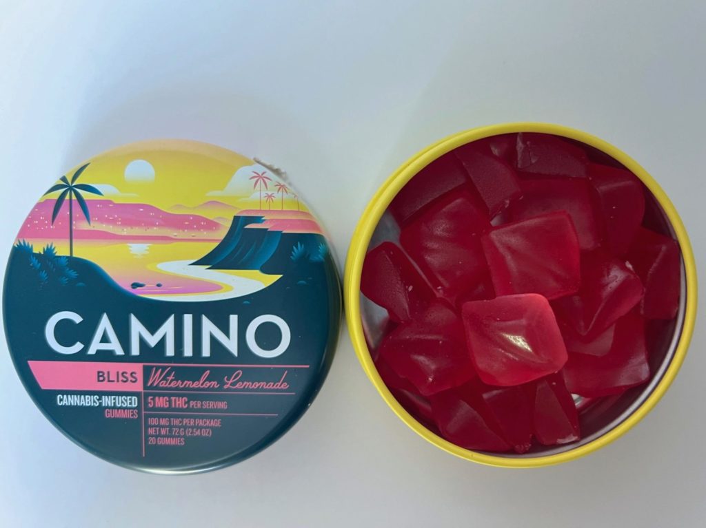Camino Bliss gummies in the flavor of watermelon lemonade in a yellow tin open revealing a full container of pink square gummies.