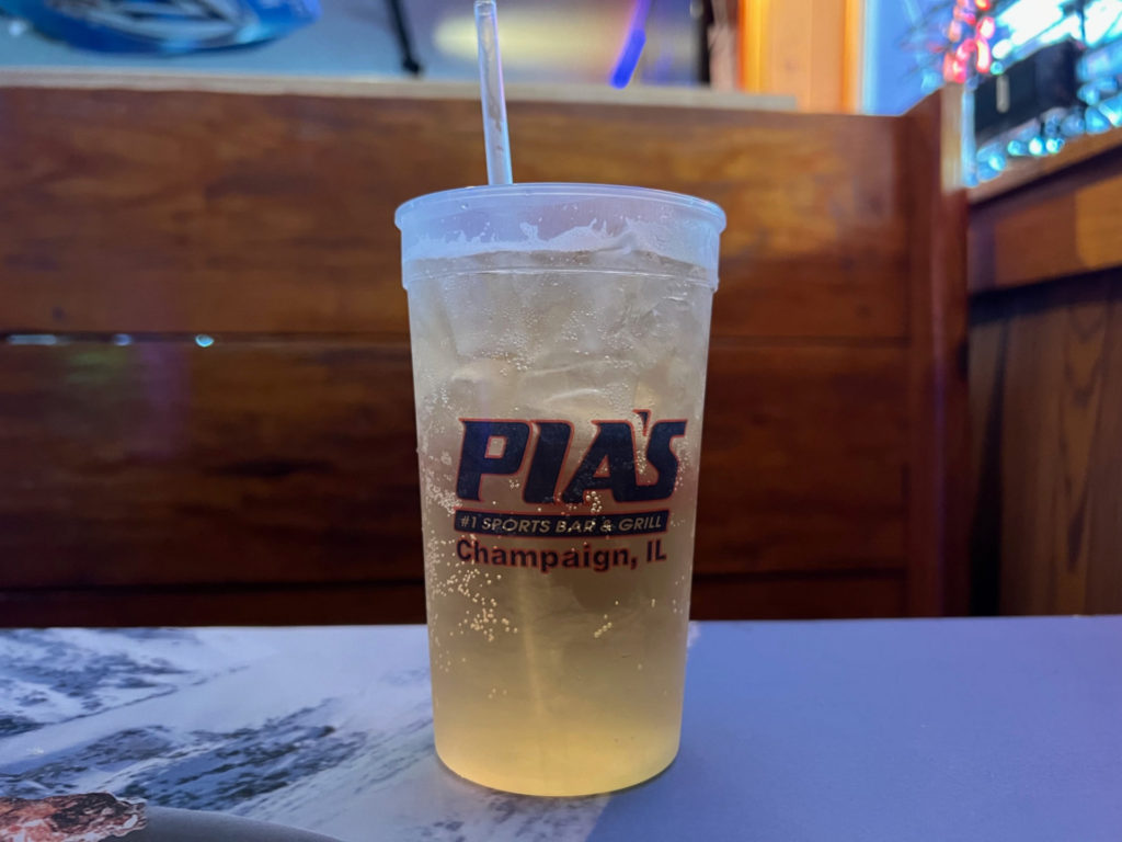 A cup of Jameson with Sprite and Coke in a plastic cup that reads "Pia's #1 Sports Bar & Grill, Champaign, IL."