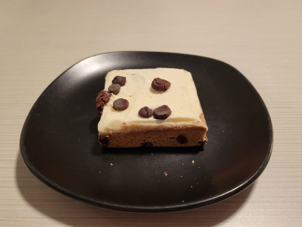 A chocolate chip cookie bar on a small black plate.