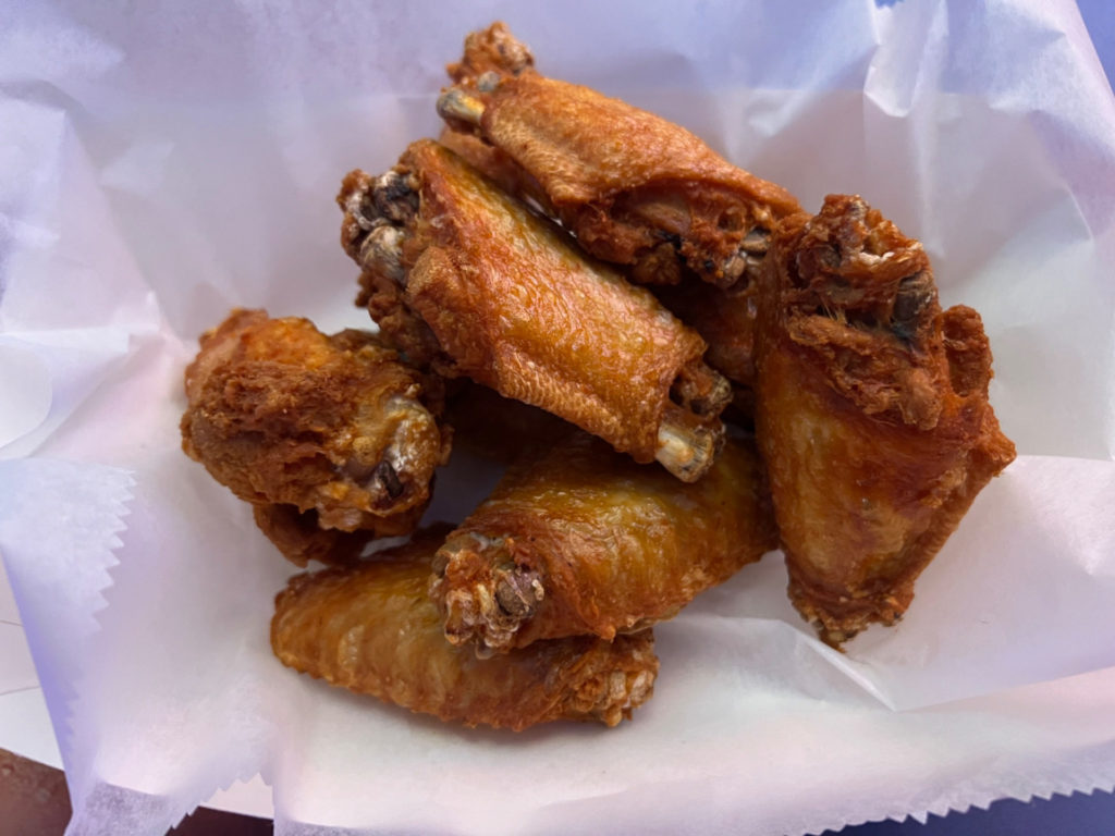 An order of ten wings in a parchment paper lined basket.