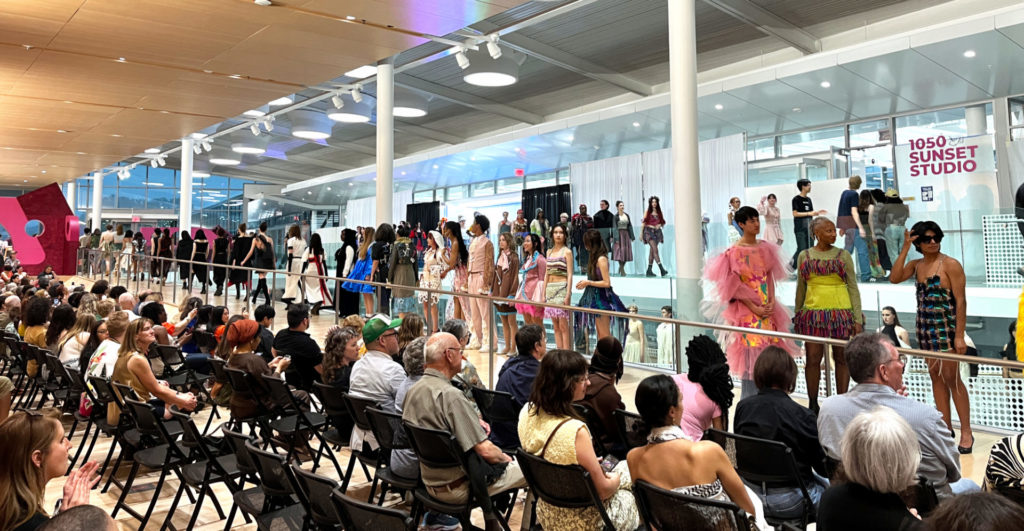 The crowd at ReFashioned 2024 watch the models line up on the "runway" at the end of the show.