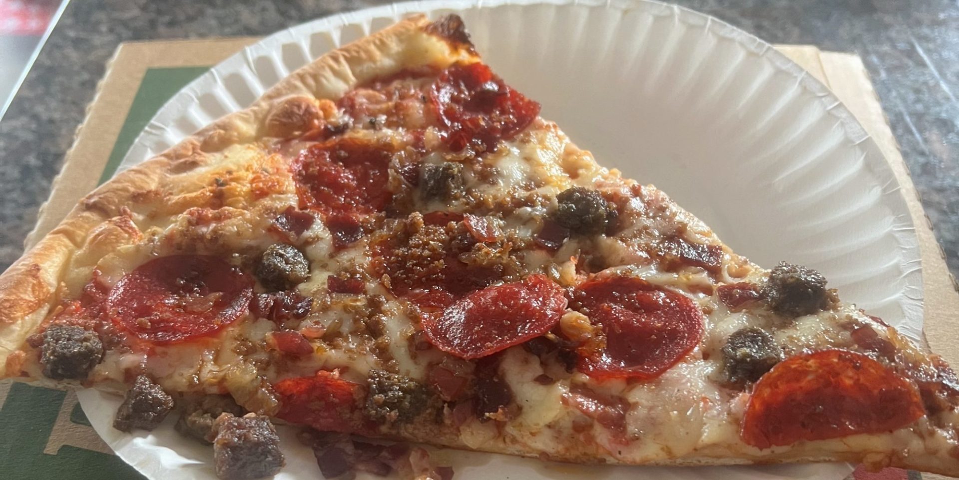 A single slice of meat lovers' pizza.